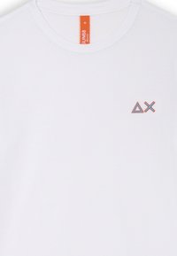 T-shirt bianca in cotone con scollo tondo e maniche corte. Sul davanti presenta un piccolo logo geometrico ricamato in blu e arancione.