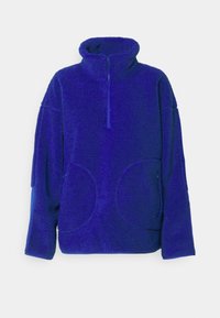 Lila fleecehoodie med hög krage, halvdragkedja framtill, oversized passform och två cirkulära fickor på framsidan, med strukturerad tyg.