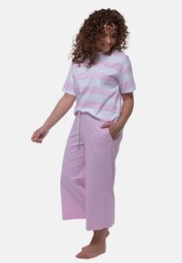 Gestreiftes T-Shirt aus Baumwolle in Pink und Weiß mit Rundhalsausschnitt und kurzen Ärmeln, kombiniert mit lockeren, rosa, knöchellangen Hosen mit Kordelzug und Taschen.
