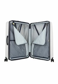 Valigia rigida bianca con accenti blu navy, dotata di doppi scompartimenti con zip, foderatura a righe e quattro ruote scorrevoli.