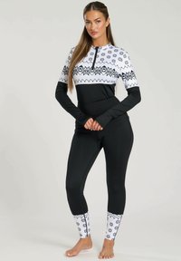 Muta intera nera con un motivo geometrico bianco e nero nella parte superiore, maniche lunghe e design lungo fino alla caviglia.