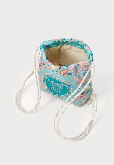 Sac seau à cordon dans un tissu turquoise avec des motifs floraux ; anses en corde tressée blanche ; présente "VERSACE" en lettres décoratives.