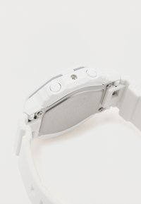 Balta laikrodis su tekstūruota silikono apyranke, sidabriniu nerūdijančio plieno nugarėle ir dviem šoninėmis mygtukais. Pasižymi tvirtu, kampuotu korpuso dizainu.