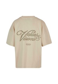 Beige kortermet oversized T-skjorte med teksten "Verdier & Visjoner" i stor kursiv skrift på ryggen, mindre tekst under.