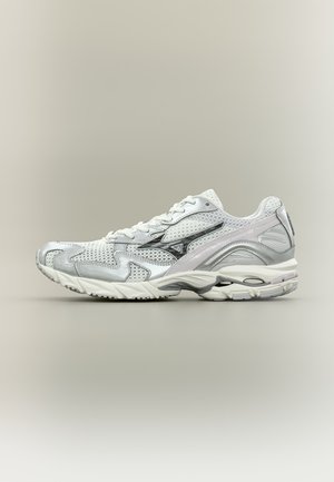 White and silver athletic sneaker with mesh upper, lace-up design, and cushioned sole, shown from the side on a plain background.
