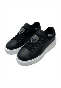 Sneakers nere in pelle con suola platform bianca, caratterizzate da una decorazione a forma di cuore argentata sui lacci e una punta arrotondata.