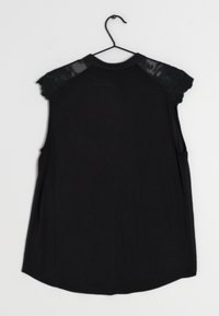 Haut noir sans manches avec épaules rehaussées de dentelle, encolure arrondie et ourlet droit. Confectionné dans un tissu doux et léger.