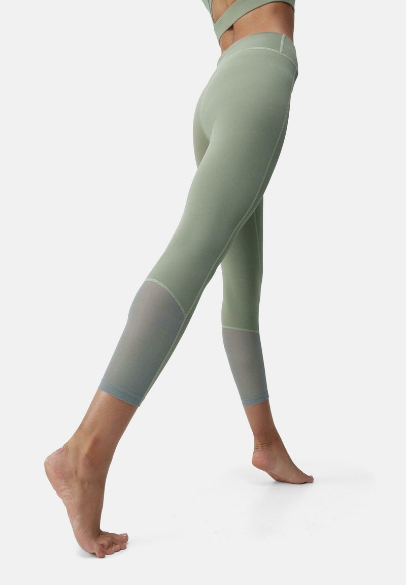 Világoszöld leggings, texturált anyagból, fitted designnal, színátmenettel az alsó lábakon és minimális varrási részletekkel.