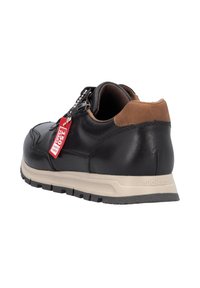 Zapatilla negra de cuero con detalles en ante marrón, superficie texturizada, diseño de cordones y suela beige. Incluye una etiqueta roja con la marca.