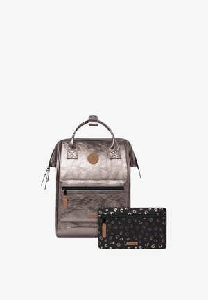 Metallic silver backpack with a textured finish, featuring a front zipper pocket and dual carry handles. Includes a black leopard-print pouch.