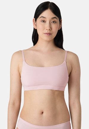 Bralette rose clair avec des fines bretelles réglables, design sans coutures et texture douce. Forme rectangulaire simple, adaptée à un port confortable.