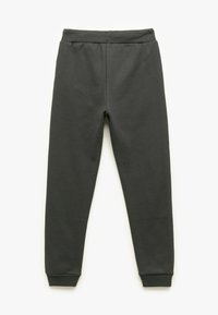 Mörkgrå sweatpants i mjukt tyg, med resårlinning och åtsittande muddar vid anklarna. Enkel och funktionell design.