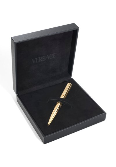 Luksuzna Versace olovka u zlatnoj boji s teksturiranim dizajnom, prikazana unutar otvorene crne kutije za poklone obložene baršunom.