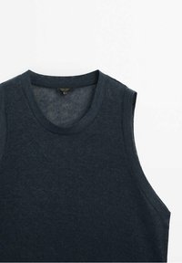 Pull tricoté sans manches bleu foncé avec col rond sur fond blanc.