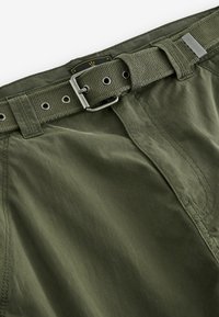 Olive zielone szorty cargo z teksturowanej tkaniny, szeroki pasek z metalową klamrą, wzmocnione szwy i naszyte kieszenie.