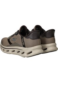 Chaussures de sport en mesh beige avec des accents marron foncé, semelle amortissante et trous de ventilation. Comprend des coutures délicates et un détail de logo.