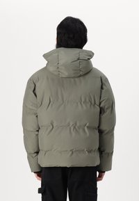 Light green puffer jacket with horizontal baffles, a hood, and a smooth texture, featuring a relaxed fit and concealed stitching.