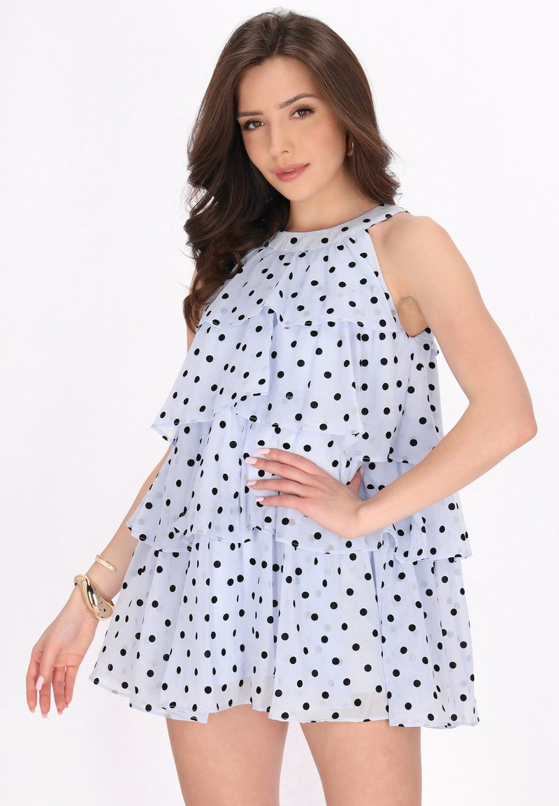 Ljusblå ärmlös klänning med svarta prickar, med lager av volanger och rund halsringning. Lätt och luftig tyg.