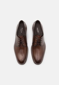 Bruine leren dresschoenen met een gladde afwerking, vijf-oog veterontwerp en subtiele stikaccenten. Rond gevormde neus.