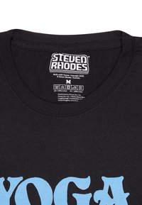 Camiseta de algodón negra con cuello redondo, con el texto azul "YOGA" en una fuente negrita. Etiqueta de cuidado impresa en el área del cuello. Talla M.