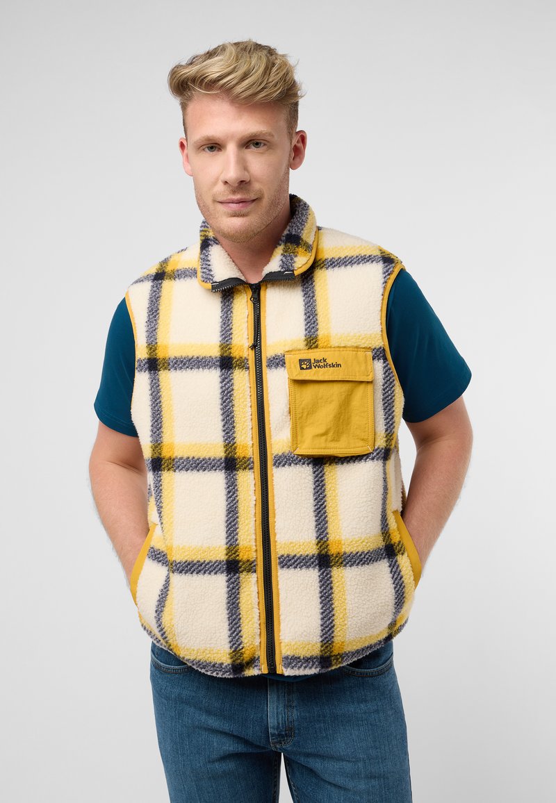 Gilet in pile con motivo a quadri giallo, nero e crema; presenta una chiusura con zip, colletto alto e tasca applicata. Indossato sopra una camicia blu.