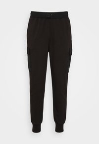 Pantalones de chándal negros confeccionados en una tela suave, con una cintura elástica ajustable, puños acanalados y bolsillos laterales tipo cargo con cierres de solapa.