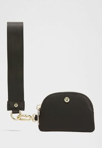 Liten svart zippered pouch med bred rem och guldtonad spänne, prydd med en rund metallisk logotyp i mitten fram.