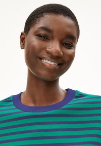 Grün und blau gestreiftes T-Shirt mit einem lila Ausschnitt, aus weichem Stoff, mit horizontalen Streifen in verschiedenen Breiten.