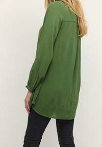 Groene blouse met lange mouwen, gemaakt van lichtgewicht stof, met een relaxte pasvorm, knoopmanchetten en een afgeronde zoom met zijsplitten.