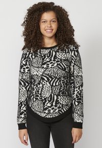 Czarny i biały sweter w wzory, z okrągłym dekoltem, długimi rękawami i miękką, teksturowaną tkaniną; charakteryzuje się geometrycznymi i abstrakcyjnymi wzorami.