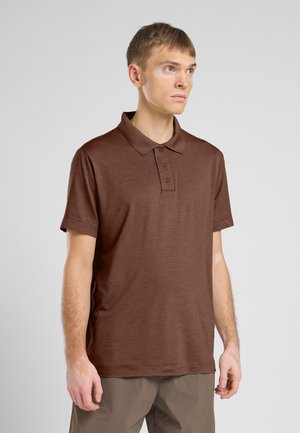 Bruine polo met korte mouwen, klassieke kraag, drie-knopen sluiting en een gestructureerde stof. Draag met lichtbruine broeken.
