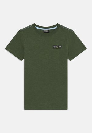 Olive green cotton t-shirt with short sleeves, round neck, and a small black and white logo patch on the chest. Soft texture with a slight sheen.