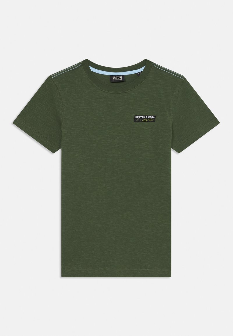 Olive green cotton t-shirt with short sleeves, round neck, and a small black and white logo patch on the chest. Soft texture with a slight sheen.