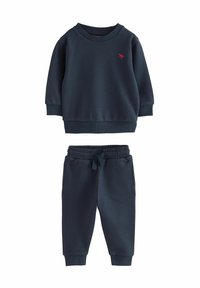 Sweat-shirt bleu marine avec des poignets et un ourlet côtelés, arborant un petit logo rouge brodé. Pantalon de survêtement assorti avec une taille élastique et des jambes fuselées.
