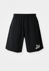 Shorts de sport noirs avec une taille élastique et un cordon de serrage, arborant un logo « JORDAN » bien visible et une petite icône rouge.