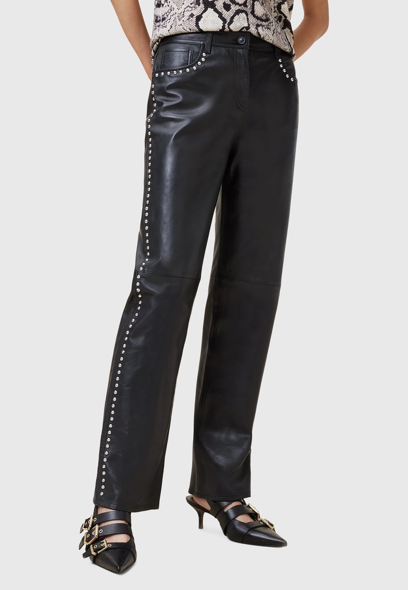 Zwarte leren broek met een recht model, versierd met zilveren studs langs de zijnaad. Gladde textuur, minimale hardware-details.