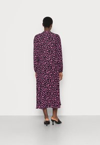 Abito midi nero con motivo floreale rosa, maniche lunghe e vestibilità ampia; presenta un collo rotondo e un orlo svasato.