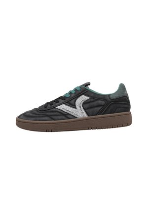 Zapatilla deportiva negra de caña baja con suela marrón, cordones azul verdoso, franja lateral gris y cuello interior acolchado.