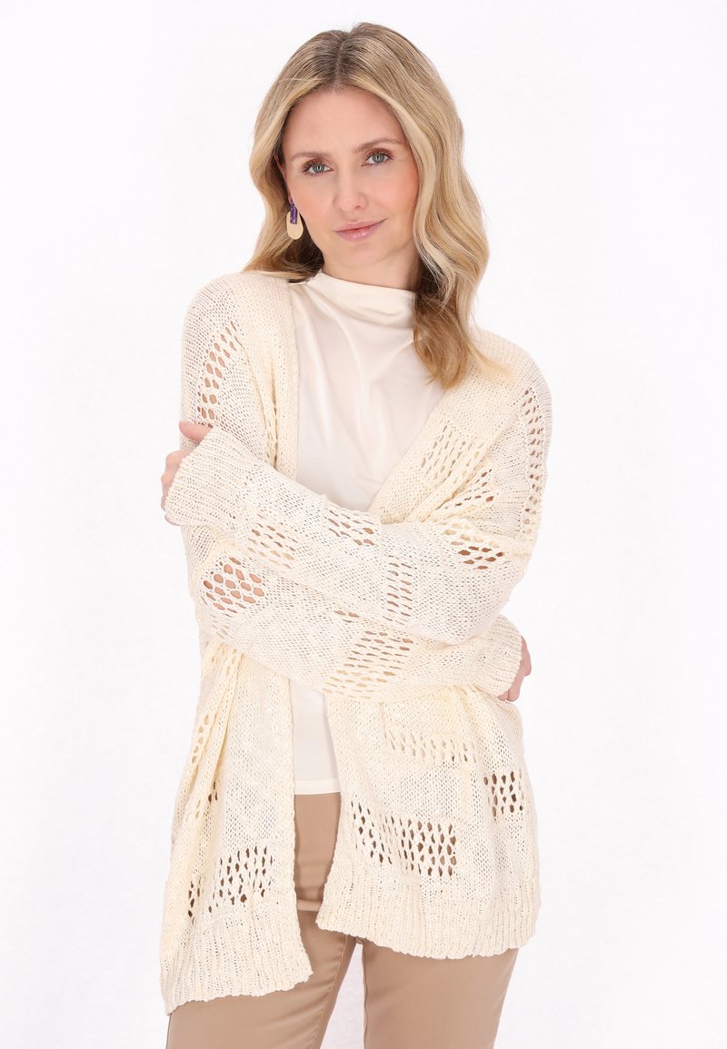Cardigan a maglia aperta con maniche lunghe in crema, dal design morbido, caratterizzato da un motivo testurizzato e polsini a coste.