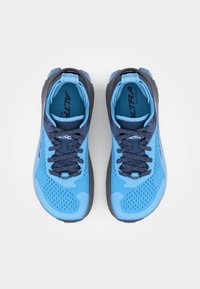 Chaussures de trail running bleues avec une tige en mesh respirant, un bout renforcé, et des lacets bleu foncé. Caractéristiques de détails texturés sur les côtés et la semelle.