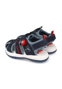 Chanclas azul marino con detalles grises, herrajes rojos y suela blanca. Cuentan con correas ajustables y un diseño abierto para mayor transpirabilidad.