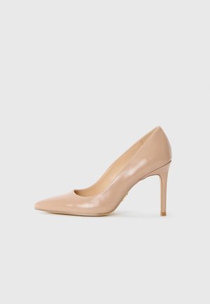 Décolleté beige in pelle con punta affilata e sottile tacco a stiletto su uno sfondo bianco uniforme.
