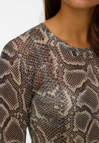 Langsleeve top met een slangenprint patroon. Het materiaal is doorschijnend met tinten bruin, beige en grijs, met een gestructureerd oppervlak.