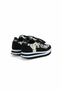 Zwart-witte sneakers met een gespikkelde bovenkant, zwarte suede accenten, platte veters en een dikke wit-zwarte gestreepte zool.