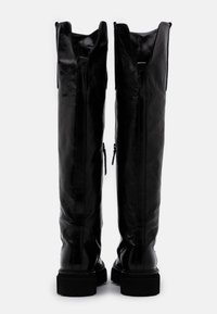 Stivali al ginocchio in pelle nera con una texture liscia, dotati di una suola rinforzata, doppie cerniere e un'apertura ampia nella parte superiore.