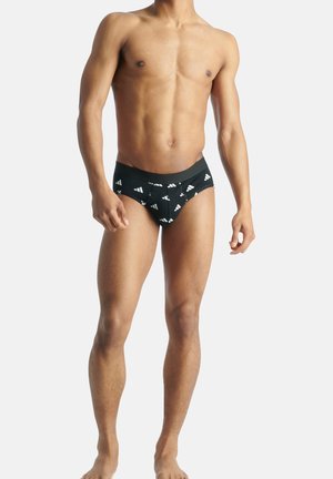 Schwarze Schwimmslips mit weißem Logomuster, im betonten Design und mit glatter Textur, geeignet für Bademode. Mit elastischem Bund.