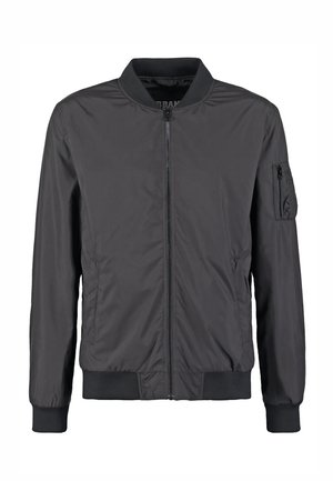 Juoda bombonešio striukė su priekinio užtrauktuko užsegimu, ribinėmis apykaklėmis, rankogaliais, apačia ir užtrauktuku kairiojo rankovės kišenėje.