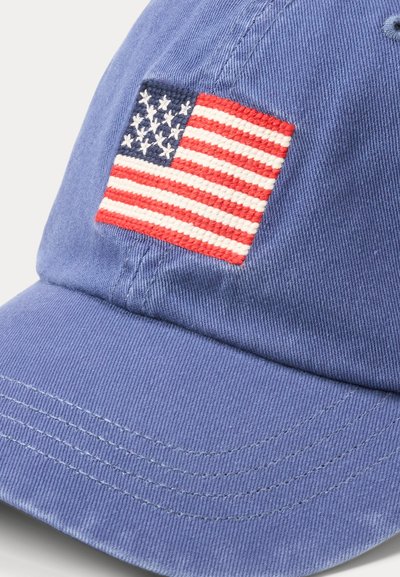 Sinine pesapalli nokamüts, kus on õmmeldud Ameerika Ühendriikide lipu märgis, punaste ja valgete triipude ning valgete tähtedega sinisel taustal.