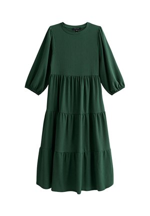 Abito verde a balze con maniche a tre quarti a palloncino, scollo rotondo e trama a coste. Realizzato con tessuto morbido e fluido.