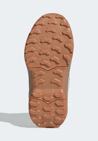 Gumová podrážka s hlubokými vzorky pro trakci, s texturovaným povrchem. Celkový tvar je zaoblený, navržený pro přilnavost a stabilitu.